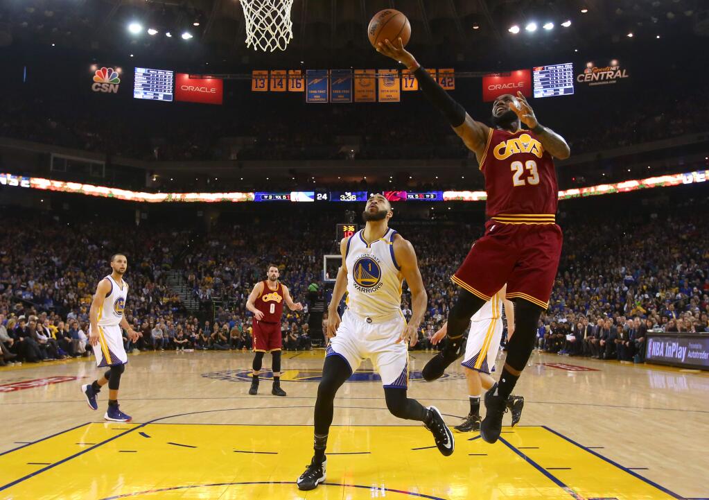 Cleveland Cavaliers forward LeBron James lays up a shot in front of Golden State Warriors center JaVale McGee during their game in Oakland on Monday, Jan. 16. The Warriors defeated the Cavaliers 126-91. (Christopher Chung / The Press Democrat)