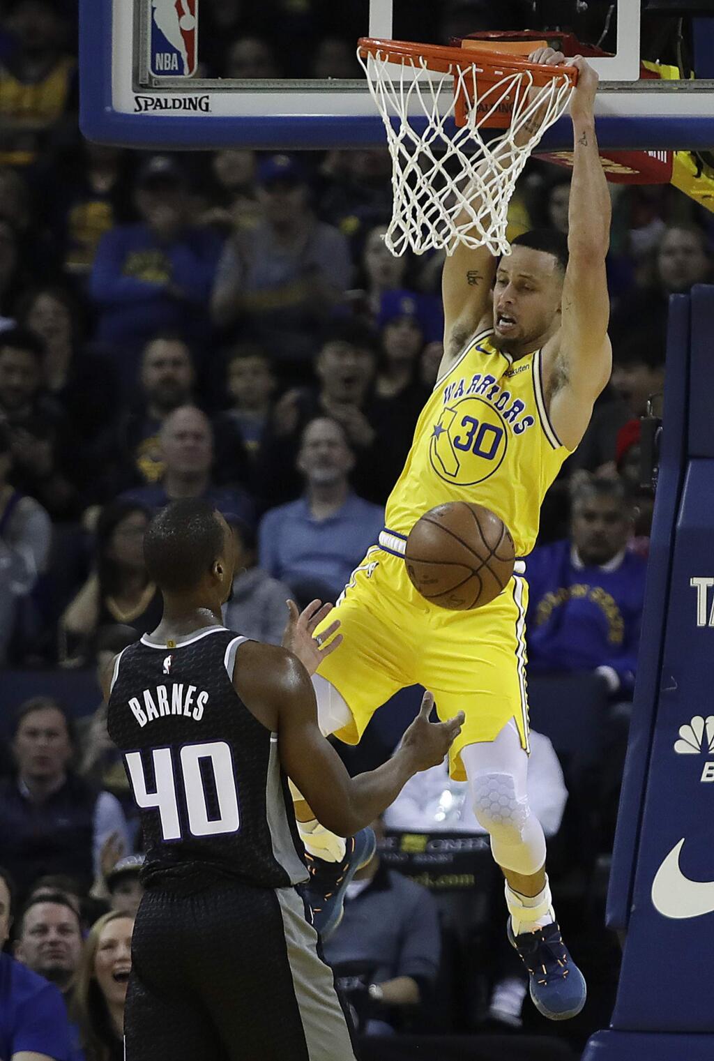The Golden State Warriors' Stephen Curry, right, scores over the Sacramento Kings' Harrison Barnes during the first half, Thursday, Feb. 21, 2019, in Oakland. (AP Photo/Ben Margot)