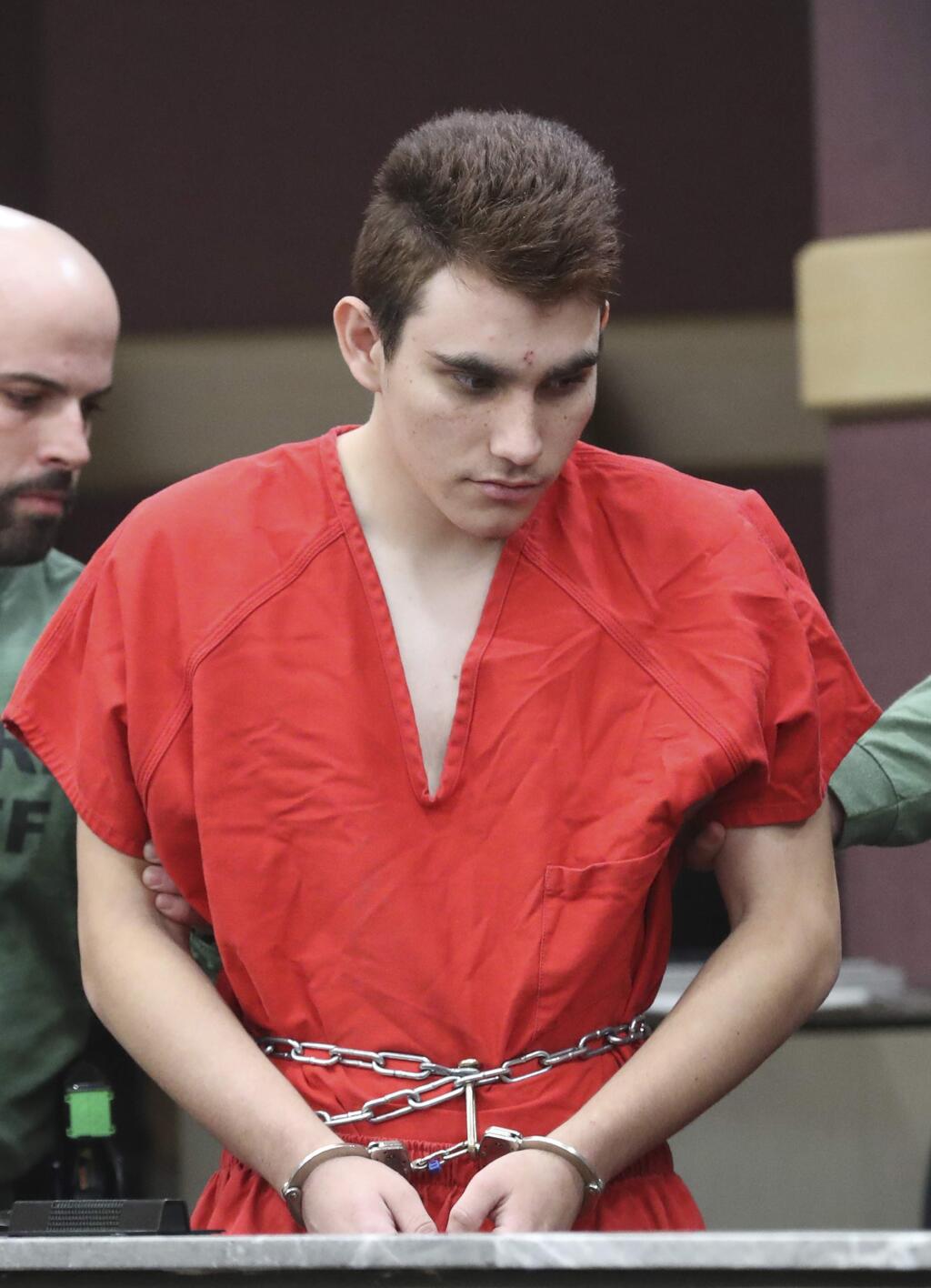 Nikolas Cruz is lead into the courtroom before being arraigned at the Broward County Courthouse in Fort Lauderdale, Fla., on Wednesday, March 14, 2018. Cruz is accused of opening fire at Marjory Stoneman Douglas High School in Parkland, Fla., Feb. 14, killing 17 students and adults. (Amy Beth Bennett/South Florida Sun-Sentinel via AP, Pool)