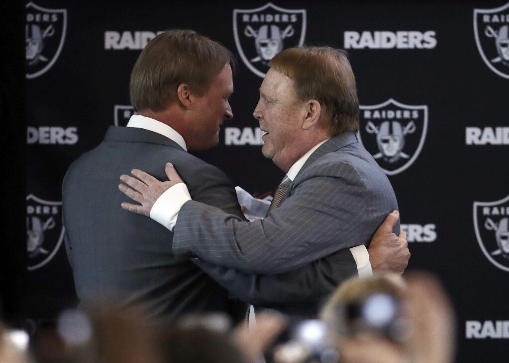 Oakland Raiders owner Mark Davis, right, hugs new head coach Jon Gruden during a press conference Tuesday, Jan. 9, 2018, in Alameda. (AP Photo/Marcio Jose Sanchez)