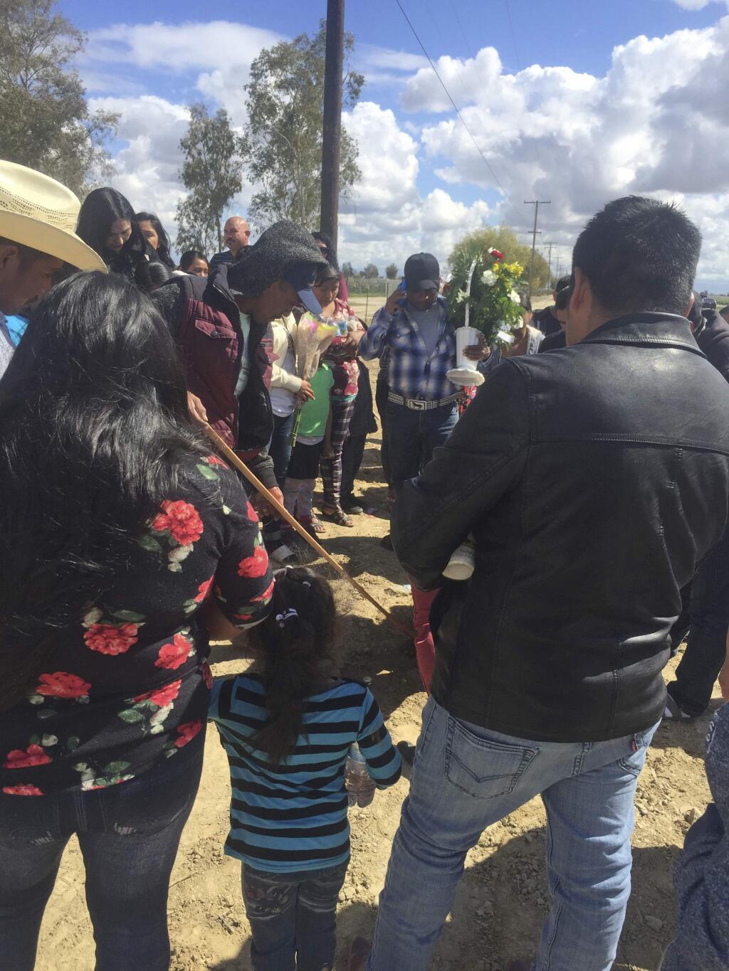 In this March 14, 2018 photo provided by the UFW Foundation, farmworkers hold a vigil in Delano, Calif., for a couple that who died after losing control of their sport utility vehicle and crashing into a power pole as they fled immigration officials in a rural California farm town. The deaths on Tuesday, March 13, 2018, happened as advocates for immigrants say U.S. immigration agents are increasingly using unmarked cars to pull over farmworkers in the state's agricultural heartland as part of the Trump Administration's heightened immigration crackdown in California. (UFW Foundation via AP)