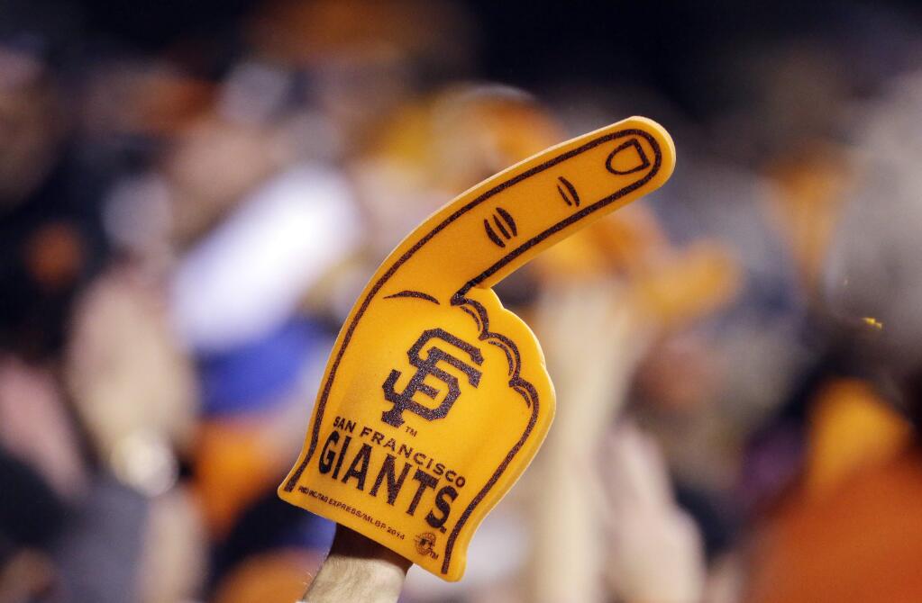 A San Francisco Giants fan cheers during the sixth inning of Game 4 of baseball's World Series between the Kansas City Royals and the San Francisco Giants on Saturday, Oct. 25, 2014, in San Francisco. (AP Photo/Charlie Riedel)