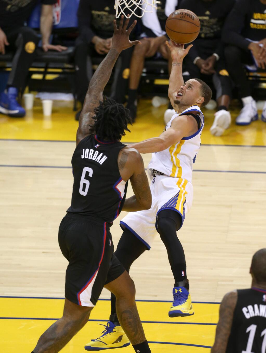 Golden State Warriors' Stephen Curry is fouled by Los Angeles Clippers' DeAndre Jordan as he goes to the basket in Oakland on Thursday, February 23. (Christopher Chung/ The Press Democrat)