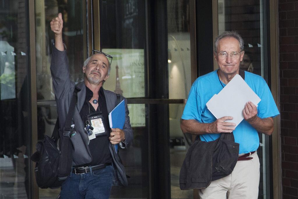 New York Daily News staff photographers Todd Maisel, left, and Andrew Savulich walk out of the newspaper's office after being laid off, Monday, July 23, 2018, in New York. The tabloid will cut half of its newsroom staff, saying it wants to focus more on digital news. (AP Photo/Mark Lennihan)