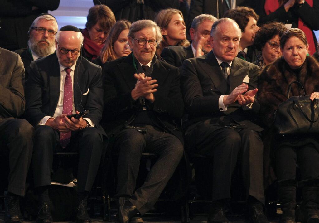 US film director Steven Spielberg, front row, second left, applauds while sitting in a tent raised at the entrance of the Birkenau Nazi death camp in Oswiecim, Poland, Tuesday, Jan. 27, 2015, during the official remembrance ceremony. About 300 survivors gathered with leaders from around the world to remember the 1.1 million people killed at Auschwitz-Birkenau and the millions of others killed in the Holocaust. (AP Photo/Czarek Sokolowski)