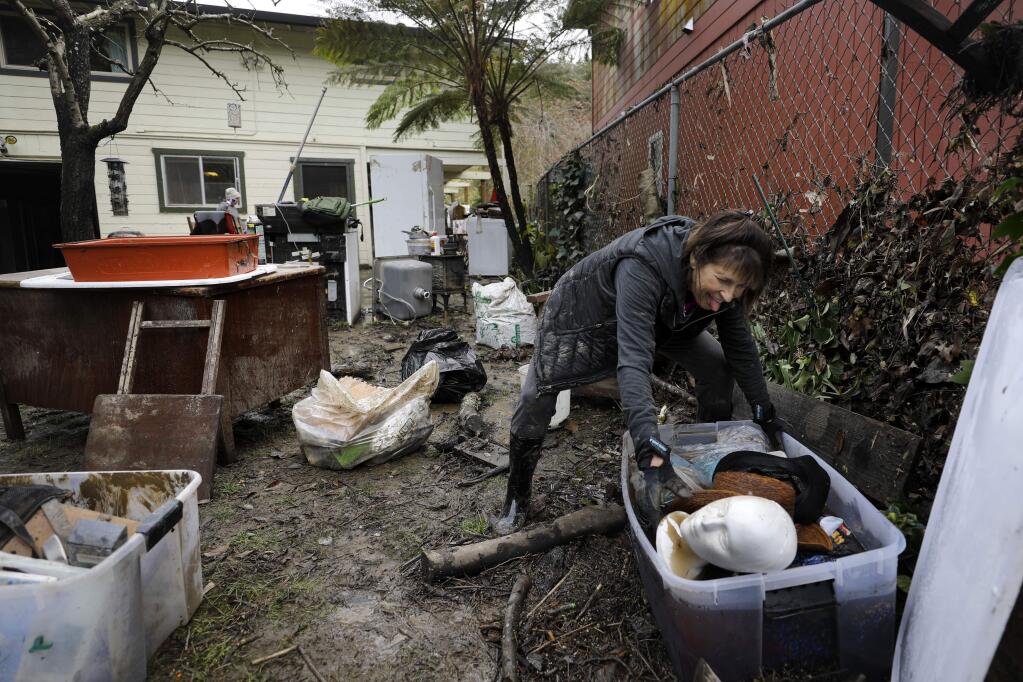 Kim Welty makes a face as she opens up a box of hats filled with floodwater at the home of her friend Alice Teeter in Forestville, California on Sunday, March 3, 2019 . (BETH SCHLANKER/The Press Democrat)