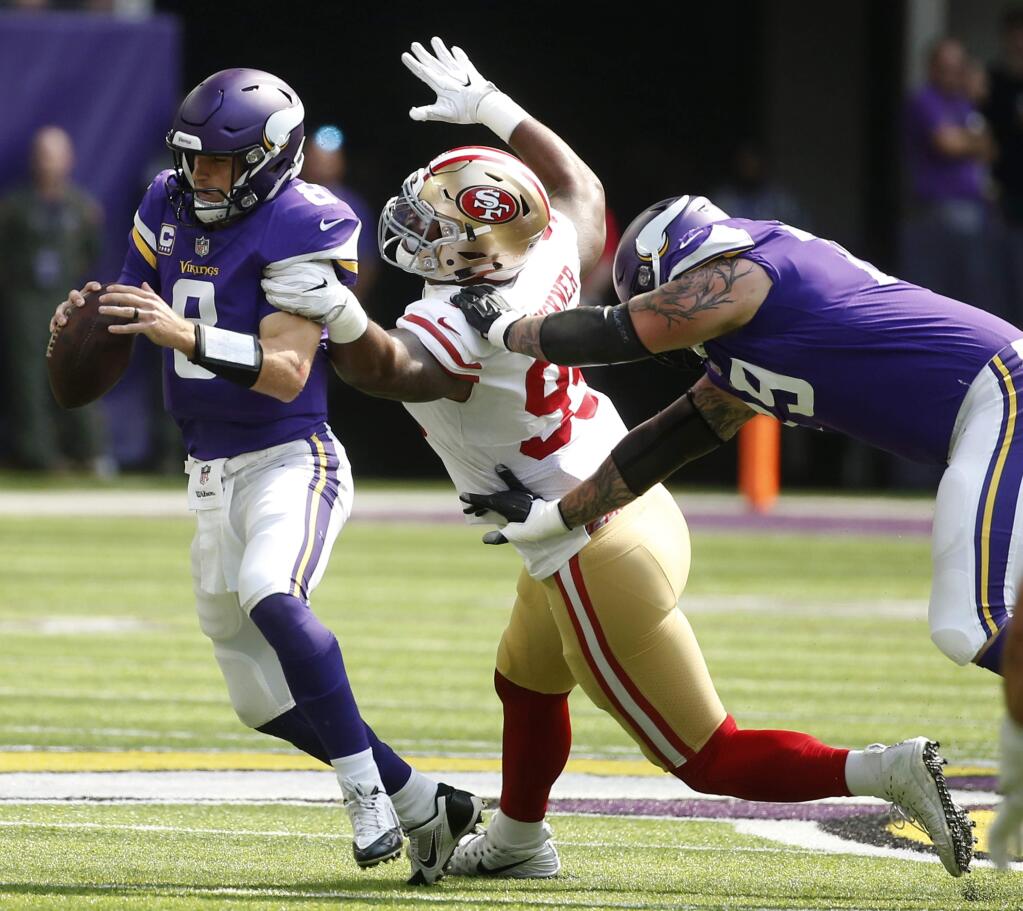 Minnesota Vikings quarterback Kirk Cousins, left, is sacked by San Francisco 49ers defensive end DeForest Buckner (99) during the first half of an NFL football game, Sunday, Sept. 9, 2018, in Minneapolis. (AP Photo/Bruce Kluckhohn)