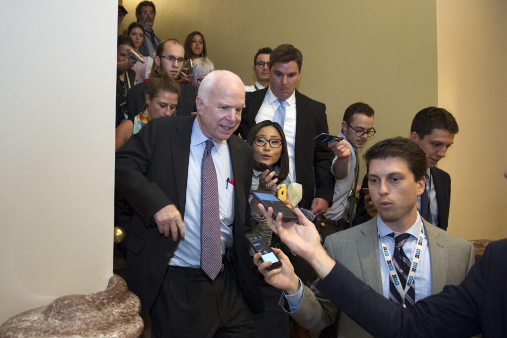 FILE - In this July 28, 2017, file photo, Sen. John McCain, R-Az., front left, is is followed by reporters after casting a 'no' vote on a a measure to repeal parts of former President Barack Obama's health care law, on Capitol Hill in Washington. (AP Photo/Cliff Owen, File)