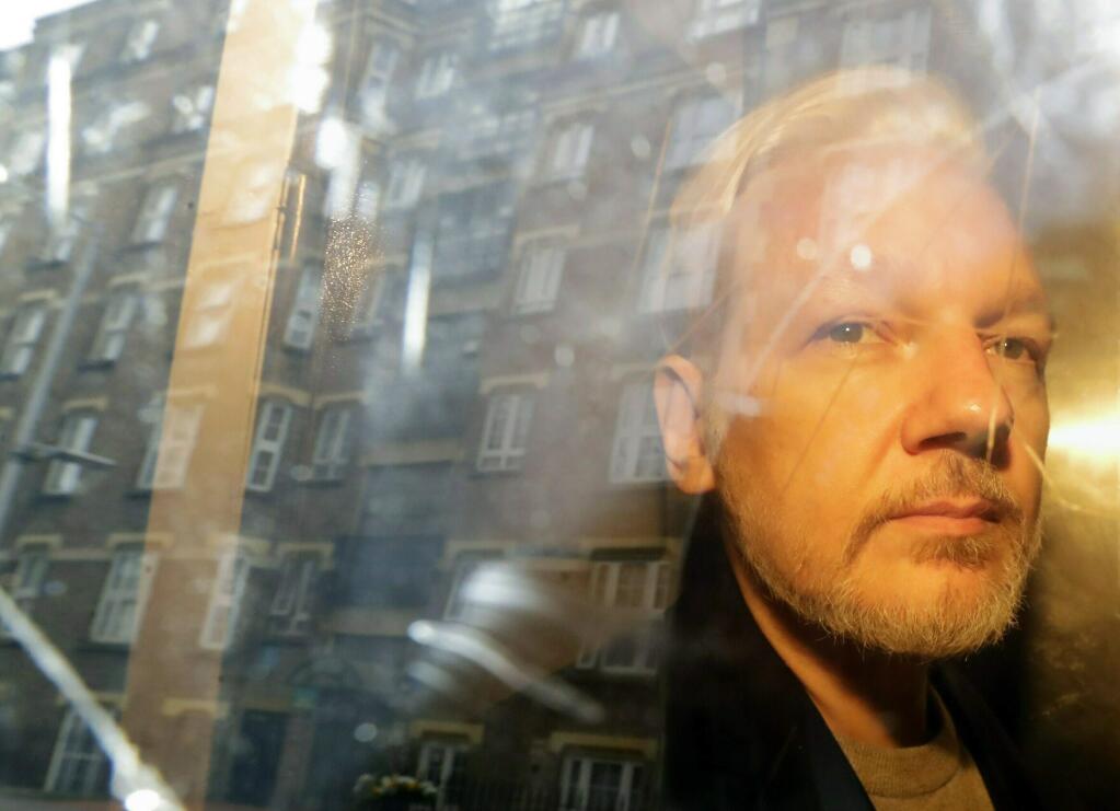 FILE - In this Wednesday, May 1, 2019 file photo, buildings are reflected in the window as WikiLeaks founder Julian Assange is taken from court, where he appeared on charges of jumping British bail seven years ago, in London. Assange has missed a court session apparently due to health problems. Assange had been expected to appear from prison via video link at a brief extradition hearing Thursday, May 30, 2019 at Westminster Magistrates' Court. (AP Photo/Matt Dunham, File)