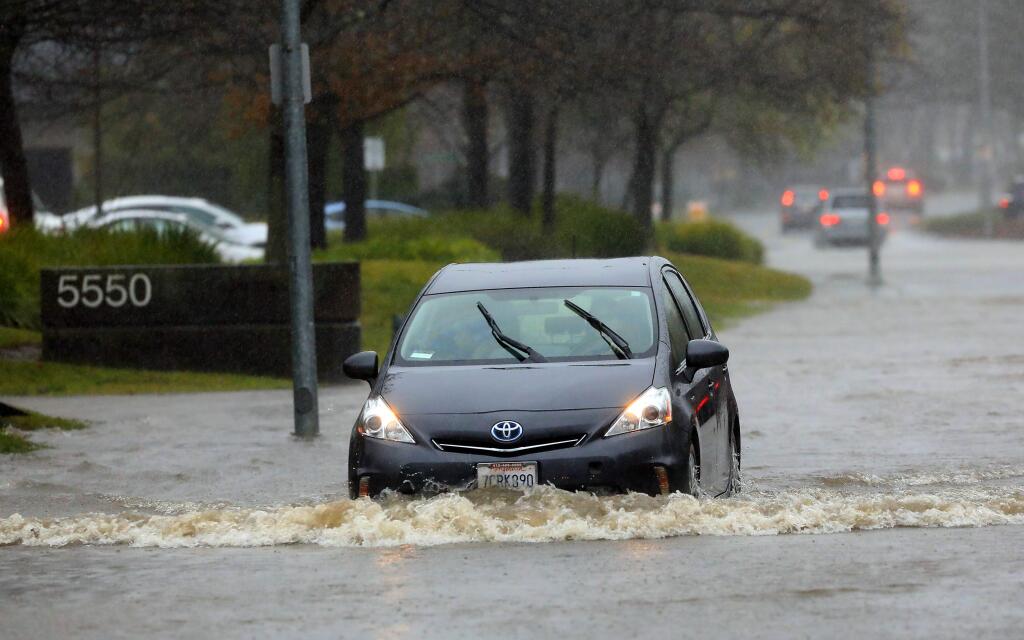 Cars make their way through a flooded Skylane Blvd. in Santa Rosa on Sunday, January 8, 2017. (John Burgess/The Press Democrat)
