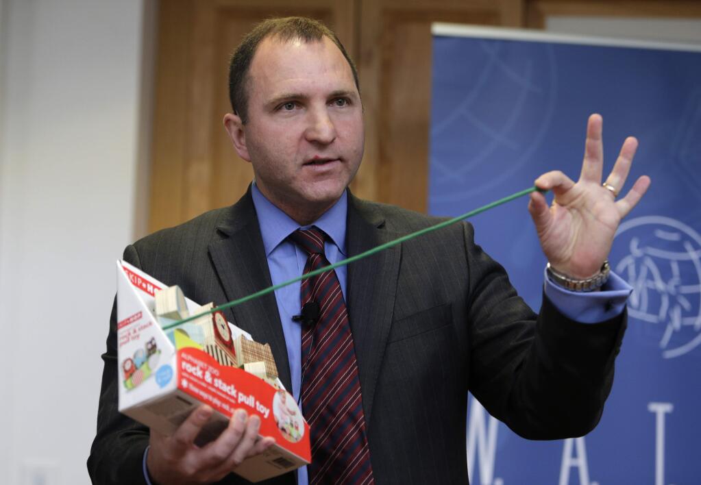 James Swartz, director of World Against Toys Causing Harm Inc., holds up a string on a children's pull toy at Children's Franciscan Hospital in Boston, Wednesday, Nov. 19, 2014. The consumer watchdog group has released its annual list of what it considers to be the 10 most unsafe toys as the holiday season approaches. (AP Photo/Charles Krupa)