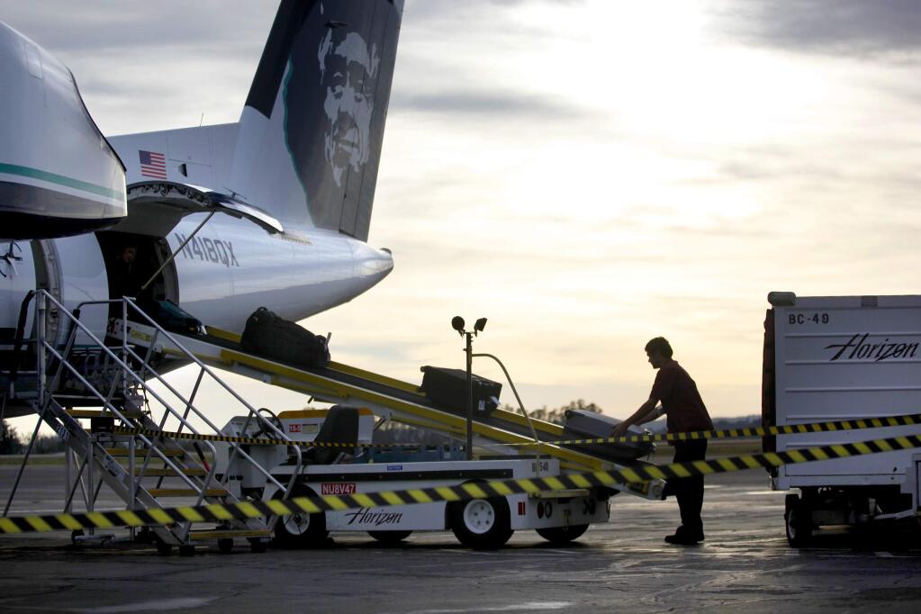 Baggage is unloaded from an Alaska Airlines flight arriving from Portland at the Sonoma County airport in 2017. (BETH SCHLANKER/ PD)