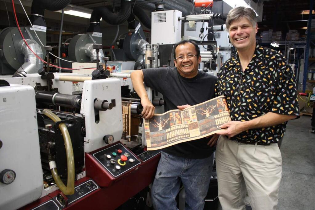 Paragon Label print shop supervisor Jeff Xayavong, left, and Jason Grossman, CEO, show some of the company's web-fed wood veneer wine labels coming off a line at the Petaluma plant on Jan. 30, 2013. (GARY QUACKENBUSH / FOR NORTH BAY BUSINESS JOURNAL)