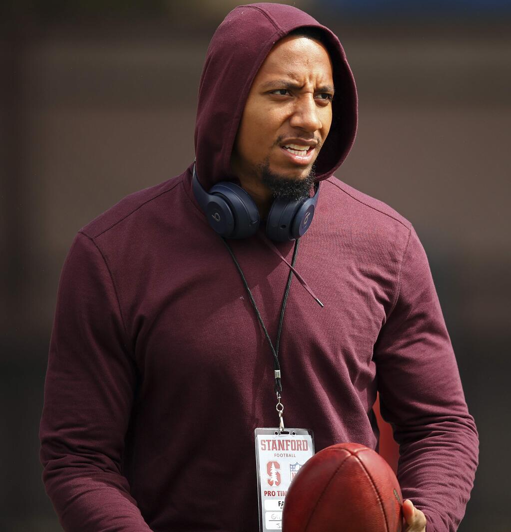 In this March 22, 2018, file photo, free agent safety Eric Reid watches Stanford's NFL Pro Day. The NFL players' union says former San Francisco 49ers safety Eric Reid filed a grievance against the league, alleging that he remains unsigned as a result of collusion by owners. Reid had joined former teammate Colin Kaepernick two seasons ago in kneeling during the national anthem to protest police brutality and racial inequality.(AP Photo/Ben Margot, File)