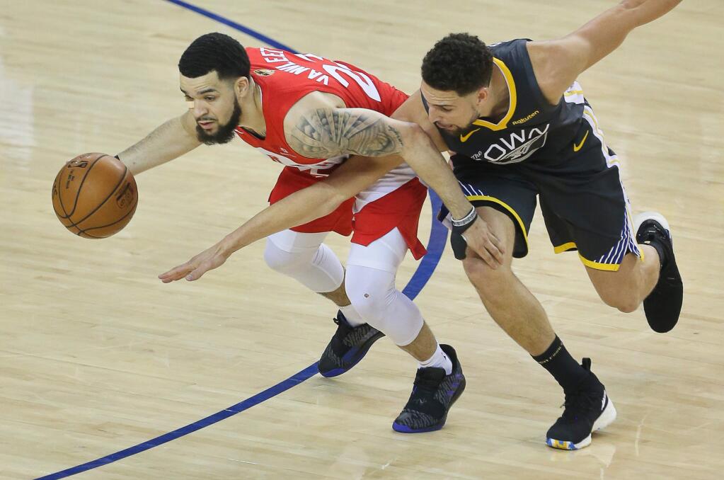 Golden State Warriors guard Klay Thompson tries to poke the ball away from Toronto Raptors guard Fred VanVleet during game 6 of the NBA Finals in Oakland on Thursday, June 13, 2019. (Christopher Chung/ The Press Democrat)