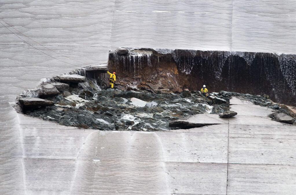 Water trickles down as workers inspect part of the Lake Oroville spillway failure on Wednesday, Feb. 8, 2017 in Oroville, Calif. The Department of Water Resources said the erosion at Lake Oroville does not pose a threat to the earthen dam or public safety, and the reservoir has plenty of capacity to handle the continuing rain. (Randy Pench/The Sacramento Bee via AP)