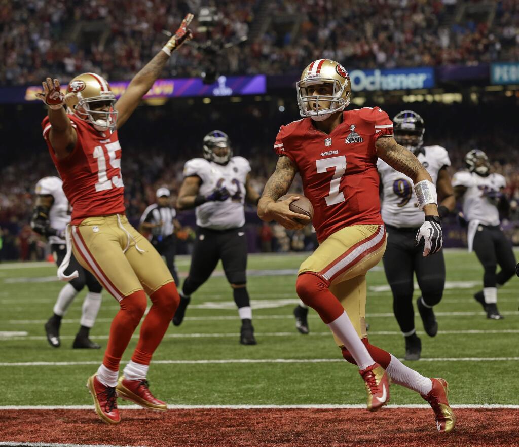 San Francisco 49ers quarterback Colin Kaepernick crosses the goal line for a touchdown as wide receiver Michael Crabtree reacts in the fourth quarter of the Super Bowl XLVII against the Baltimore Ravens, Sunday, Feb. 3, 2013, in New Orleans. (AP Photo/Dave Martin)