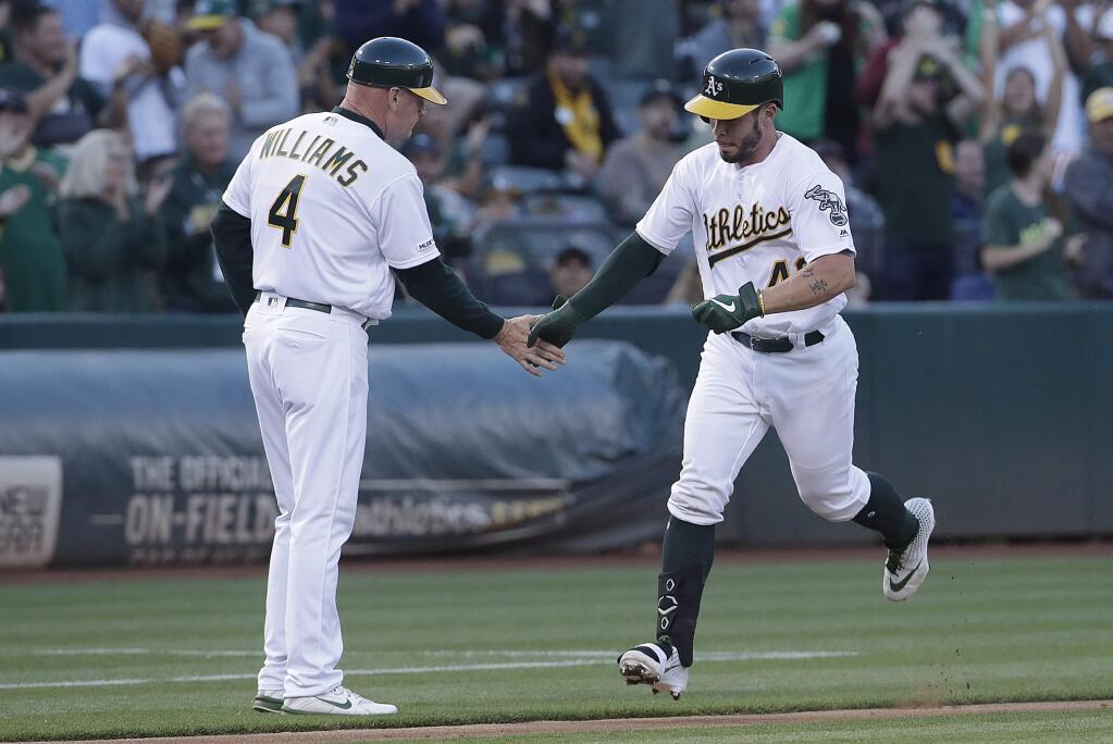 The Oakland Athletics' Beau Taylor, right, is congratulated by third base coach Matt Williams after hitting a solo home run against the Baltimore Orioles during the third inning in Oakland, Tuesday, June 18, 2019. (AP Photo/Jeff Chiu)