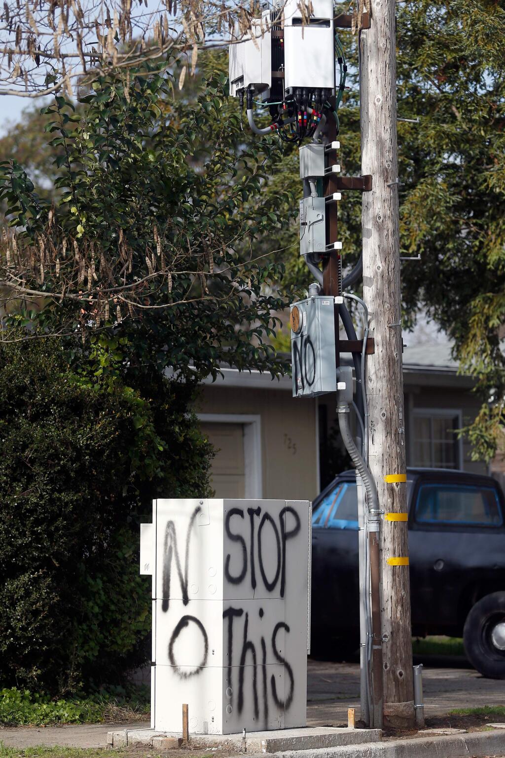 Graffiti done by an unknown person covers the in-ground utility box and part of the related cell signal booster on a utility pole in Santa Rosa. Neighbors objected to the Verizon equipment being installed without their knowldge. (Alvin Jornada / The Press Democrat)