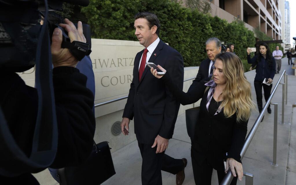 FILE - In this Dec. 3, 2018 file photo Republican Rep. Duncan Hunter, center, leaves court in San Diego. Hunter of has acknowledged taking a photo with a dead combatant during his time as a Marine as he defended a Navy SEAL charged with multiple war crimes. The Republican congressman made the comments during a town hall in his San Diego-area district. (AP Photo/Gregory Bull, File)