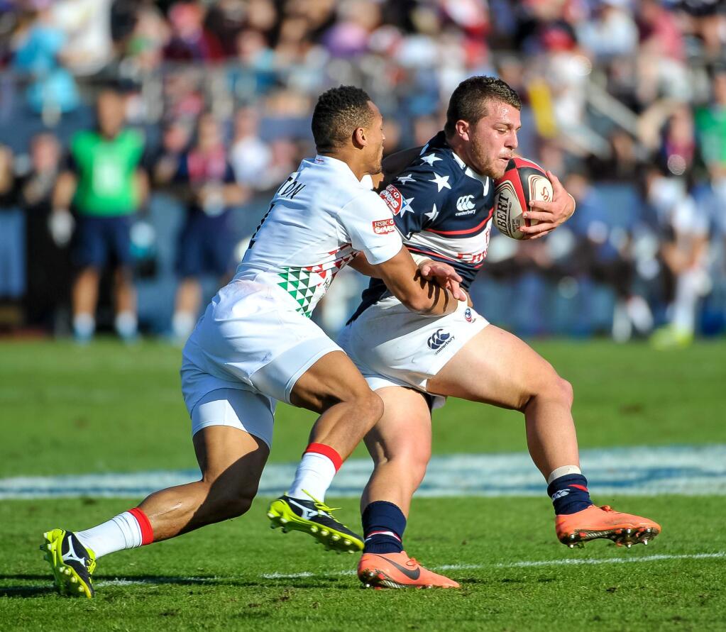 Stephen Tomasin, carrying the ball in a match in the Emirates Dubai Rugby Sevens in Dubai, is in the player pool from which the U.S. Olympic rugby team will be chosen this month. (Stephen Hindley / Associated Press)