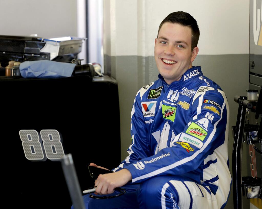 FILE - In this Feb. 17, 2017, file photo, Alex Bowman smiles to team members in his garage during a practice session for a NASCAR auto race at Daytona International Speedway, in Daytona Beach, Fla. Dale Earnhardt Jr. got the replacement he wanted. Alex Bowman got his dream job.Hendrick Motorsports announced Thursday, July 20, 2017, that the 24-year-old Bowman will replace one of the series' biggest stars in the No. 88 car next season after Earnhardt retires. (AP Photo/Terry Renna, File)