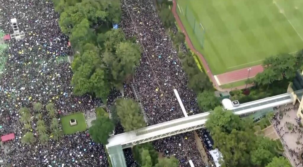 In this image from video and taken with a drone, a crowd of protesters march after leaving Victoria Park in Hong Kong, Sunday, June 16, 2019. Hong Kong citizens marched for hours Sunday in a massive protest that drew a late-in-the-day apology from the city's top leader for her handling of legislation that has stoked fears of expanding control from Beijing in this former British colony.(Cable TV Hong Kong via AP)