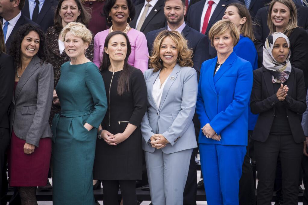 Democratic women in the front row at a photo for incoming House of Representatives freshme. From left: Xochitl Torres Small of New Mexico; Chrissy Houlahan of Pennsylvania; Gina Ortiz Jones of Texas; Lucy McBath of Georgia; Susie Lee of Nevada and Ilhan Omar of Minnesota. (SARAH SILBIGER / New York Times)