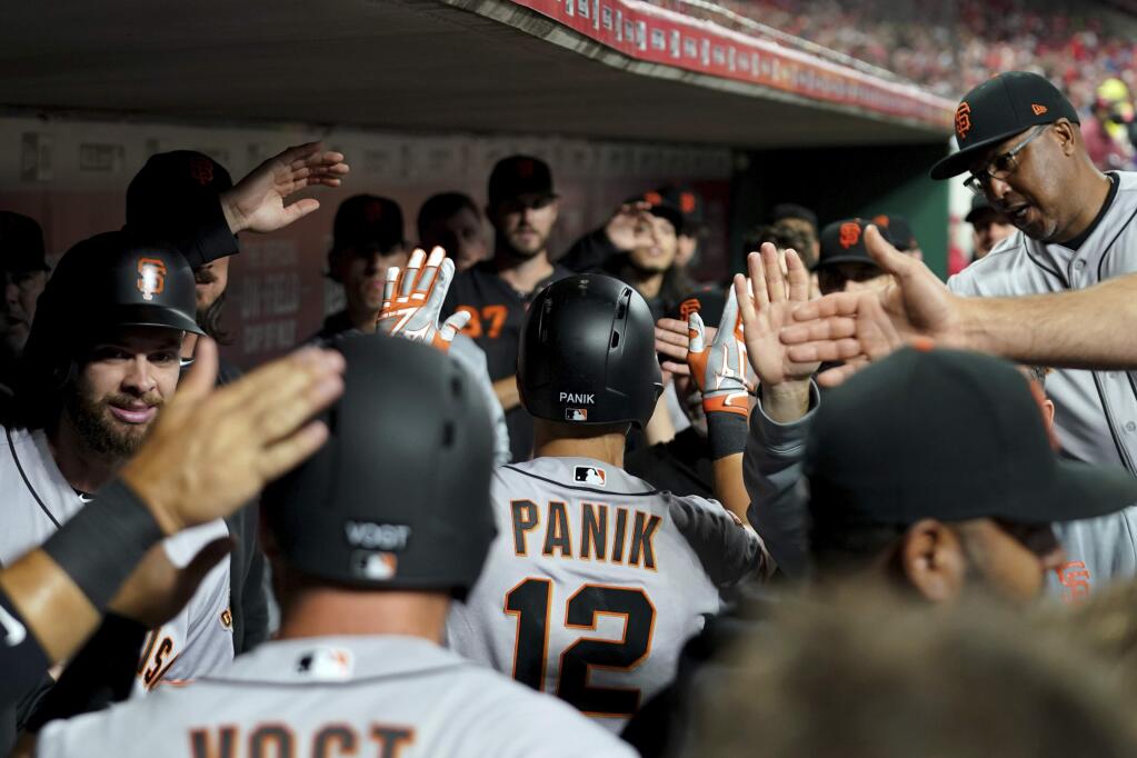 the San Francisco Giants' Joe Panik celebrates with teammates after hitting a two-run home run in the sixth inning against the Cincinnati Reds, Friday, May 3, 2019, in Cincinnati, Ohio. (AP Photo/Aaron Doster)