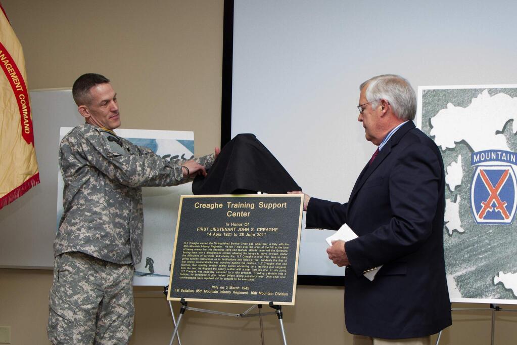 Col. David S. Doyle, commander of 2nd Brigade Combat Team, 10th Mountain Division (Light Infantry), left, and Steve Creaghe, nephew of 1st Lt. John S. Creaghe, right, unveil a plaque that will be on display at the Lt. John S. Creaghe Training Support Center during a memorialization ceremony in Lt. Creaghe's honor at the center in Fort Drum, New York. (U.S Army Photo by Spc. Osama Ayyad, 10th Mountain Division (Light Infantry) Public Affairs Office)