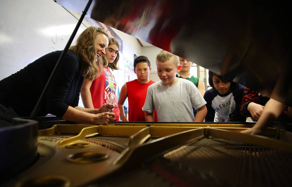 Music teacher Sadie Sonntag, left, explains the inner workings of a piano to band students Elizabeth Lovera, Ka'io Gaspar-Thompson, Stone Carroll, D.J. Ramalia and Jonathan Johanson at Forestville Academy, in Forestville, on Monday, October 26, 2015. (Christopher Chung/ The Press Democrat)