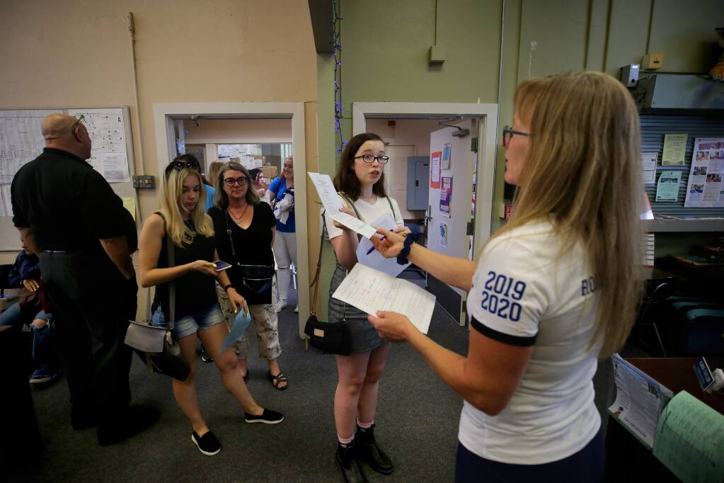 Ione Dellos, 17, turns in a form needed to take AP Biology to counseling secretary Karin Taylor during registration at Analy High School in Sebastopol on Wednesday, August 7, 2019. (BETH SCHLANKER/ The Press Democrat)