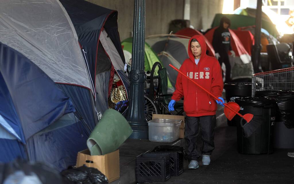 Homeless individuals were busy cleaning the Sixth Street encampment over crossing in Santa Rosa, Wednesday Nov.1, 2017. (Kent Porter / The Press Democrat) 2017