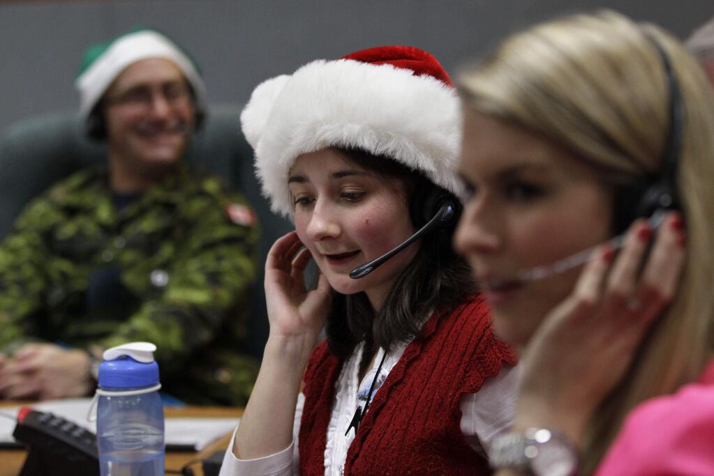 FILE - In this Dec. 24, 2012, file photo, volunteer Katherine Beaupre takes phone calls from children asking where Santa is and when he will deliver presents to their house, during the annual NORAD Tracks Santa Operation, at the North American Aerospace Defense Command, or NORAD, at Peterson Air Force Base, Colo. Santa is poised for another monster year on social media. NORAD Tracks Santa has already attracted a record 1.49 million Facebook likes before the journey even begins. And for Christmas Eve 2014, theres a website version for smartphones. (AP Photo/Brennan Linsley, File)