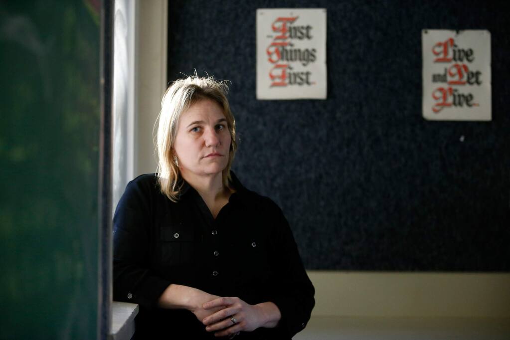 (FILE PHOTO) Tracie Parker, lead drug testing staffer in the Sonoma County Alcohol and Other Drug Services (AODS) department, poses for a portrait in front of signs with 12 Step program slogans at the Orenda Center in Santa Rosa, California, on Thursday, February 15, 2018. Parker was informed earlier this year that she would be laid off if the Board of Supervisors approved budget cuts resulting from a shortfall in the county's behavioral health division budget. Those cuts were averted but others are now proposed. (Alvin Jornada / The Press Democrat)