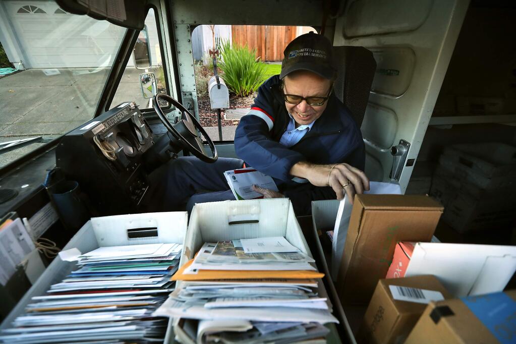 Mail carrier Rick Bertram delivers mail in the Bennett Valley area of Santa Rosa on Friday, December 16, 2016. (John Burgess/The Press Democrat)
