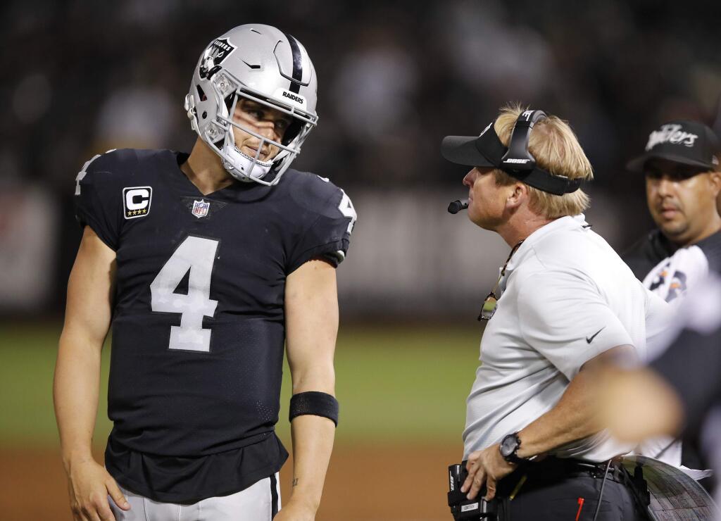 In this Monday, Sept. 10, 2018, file photo, Oakland Raiders quarterback Derek Carr talks with head coach Jon Gruden during the second half against the Los Angeles Rams in Oakland. (AP Photo/John Hefti, File)