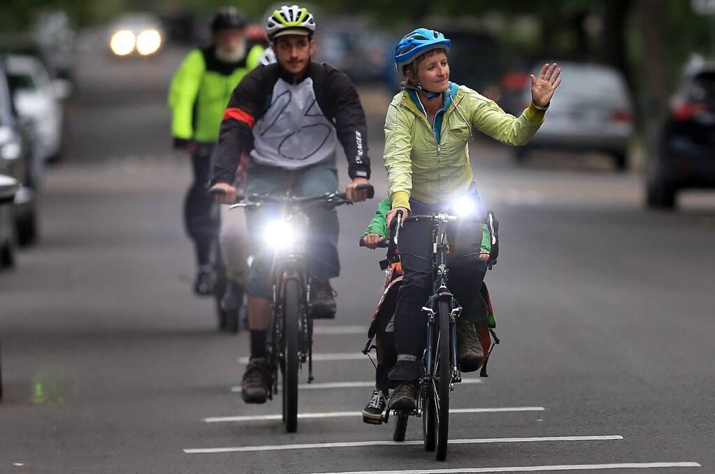 On a tandem bike, Sarah Hadler and her son Sylvester Hadley join others with the Sonoma County Bicycle Coalition in the Ride of Silence, a national movement to honor those killed or injured while cycling on public roadways, Wednesday, May 16, 2018 in Santa Rosa. (Kent Porter / The Press Democrat) 2018