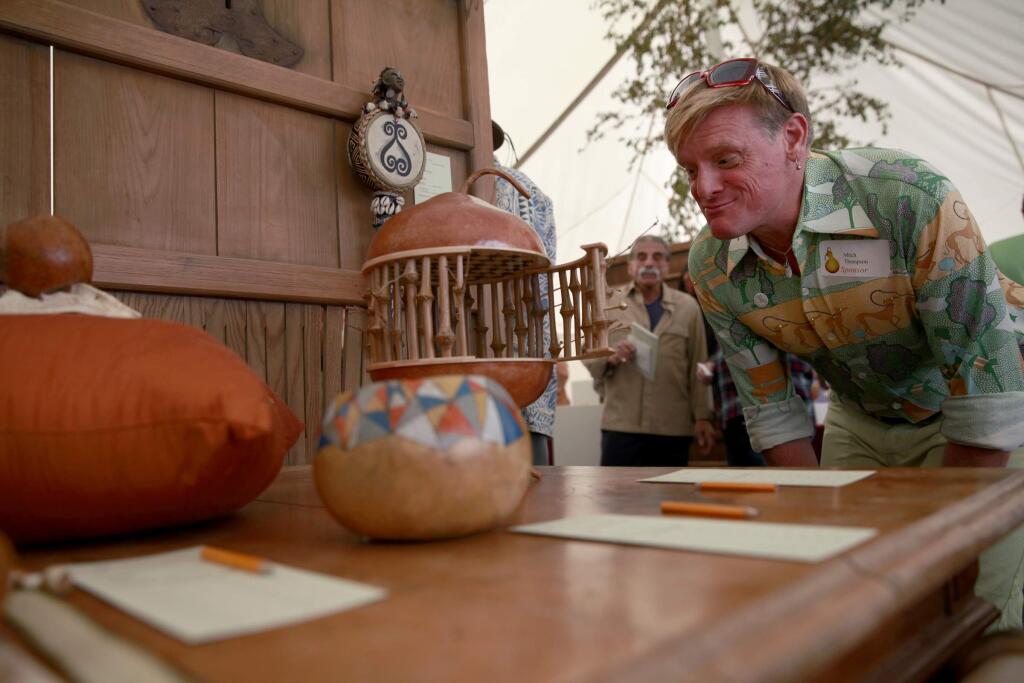 Mitch Thompson looks over the gourd art at the 2013 Calabash. (BETH SCHLANKER/ The Press Democrat)