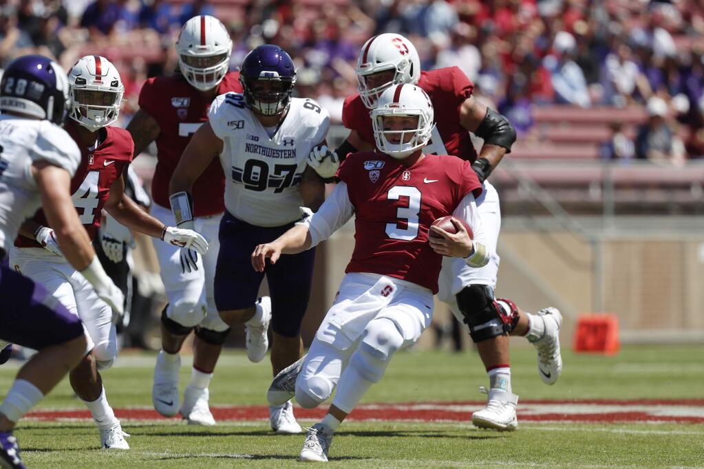Stanford quarterback K.J. Costello runs with the ball against Northwestern defensive lineman Joe Gaziano in the first quarter in Stanford, Saturday, Aug. 31, 2019. (AP Photo/Josie Lepe)
