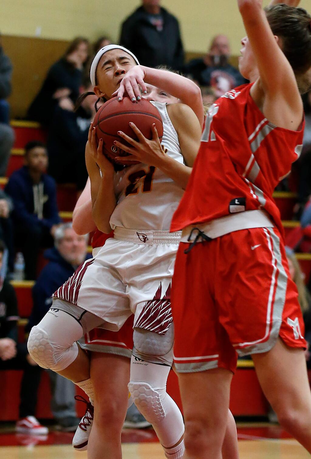 Cardinal Newman's Avery Cargill, left, gets fouled from behind by Montgomery's Ivy Lea as she attempts a layup during the first half on Tuesday, Jan. 15, 2019. (Alvin Jornada / The Press Democrat)