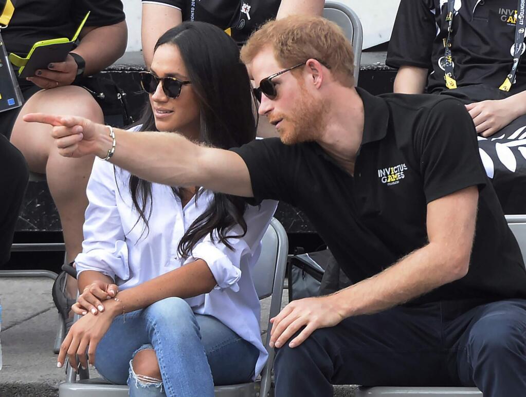 FILE - In this Monday, Sept. 25, 2017 file photo Prince Harry and his then girlfriend Meghan Markle attend a wheelchair tennis event at the Invictus Games in Toronto. (Nathan Denette/The Canadian Press via AP, FILE)