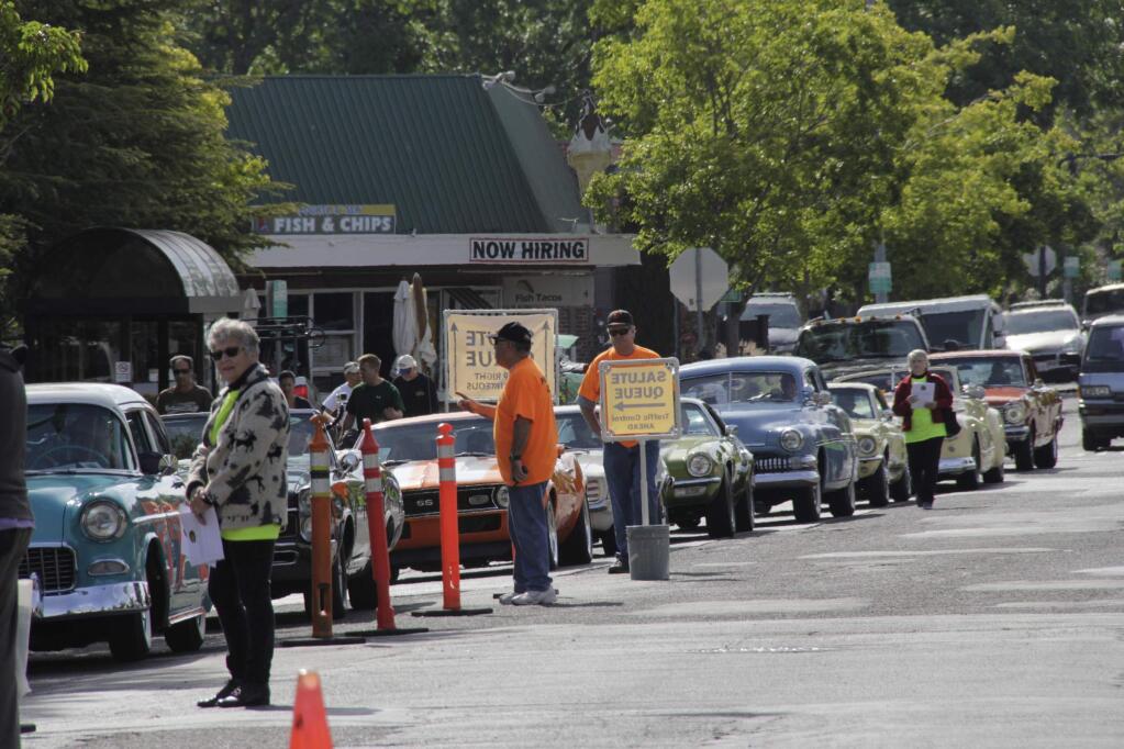 Volunteers helping the drivers to their parking spots at 'Cruising' the Boulevard' Petaluma's salute to American Graffiti on the streets of downtown on Saturday May 16, 2015. (Jim Johnson/For the Argus-Courier)