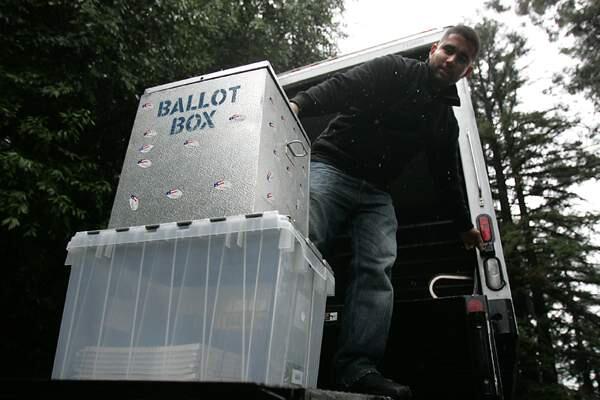 Victor Garcia unloads official ballot boxes for polling places in the Healdsburg area.
