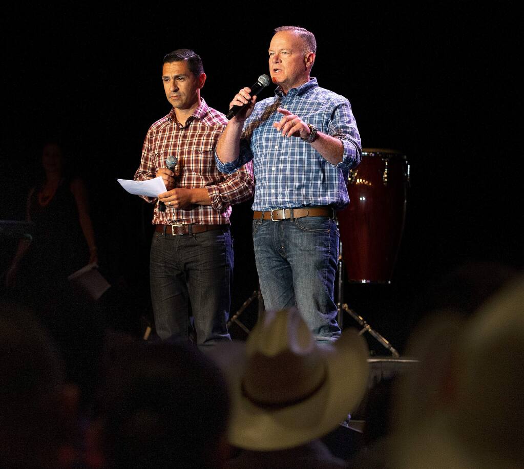 Sonoma County Sheriff Mark Essick, right, with deputy Juan Valencia translating, reaffirms his office's position of limiting cooperation between Immigration and Customs Enforcement (ICE) and Sonoma County deputies, in front of a large audience during the monthly Latin baile at Graton Resort and Casino in Rohnert Park, California, on Friday, July 26, 2019. (Alvin Jornada / The Press Democrat)