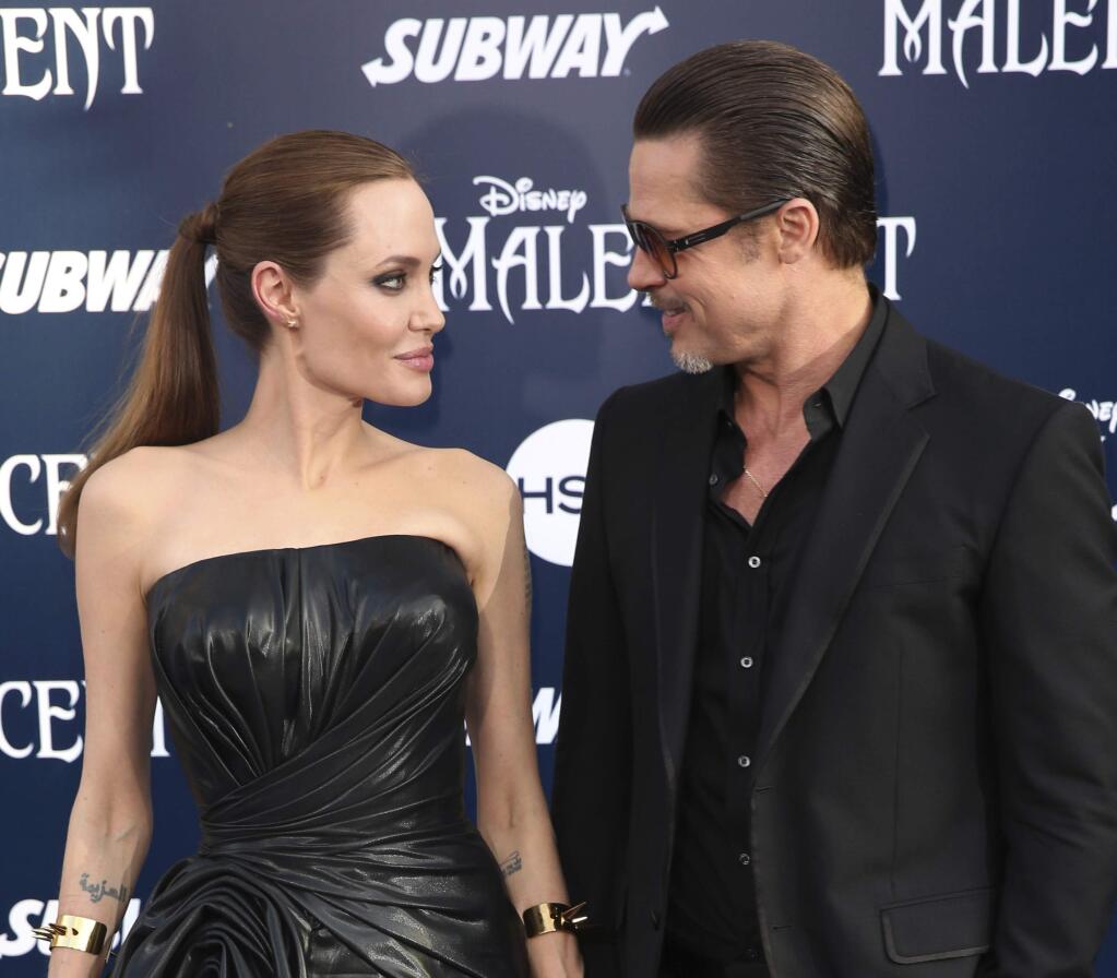 FILE - In this May 28, 2014 file photo, Angelina Jolie and Brad Pitt arrive at the world premiere of 'Maleficent' in Los Angeles. Angelina Jolie Pitt and Brad Pitt have reached an agreement to handle their divorce in a private forum and will work together to reunify their family, the actors announced in a joint statement Monday, Jan. 9, 2017. (Photo by Matt Sayles/Invision/AP, File)