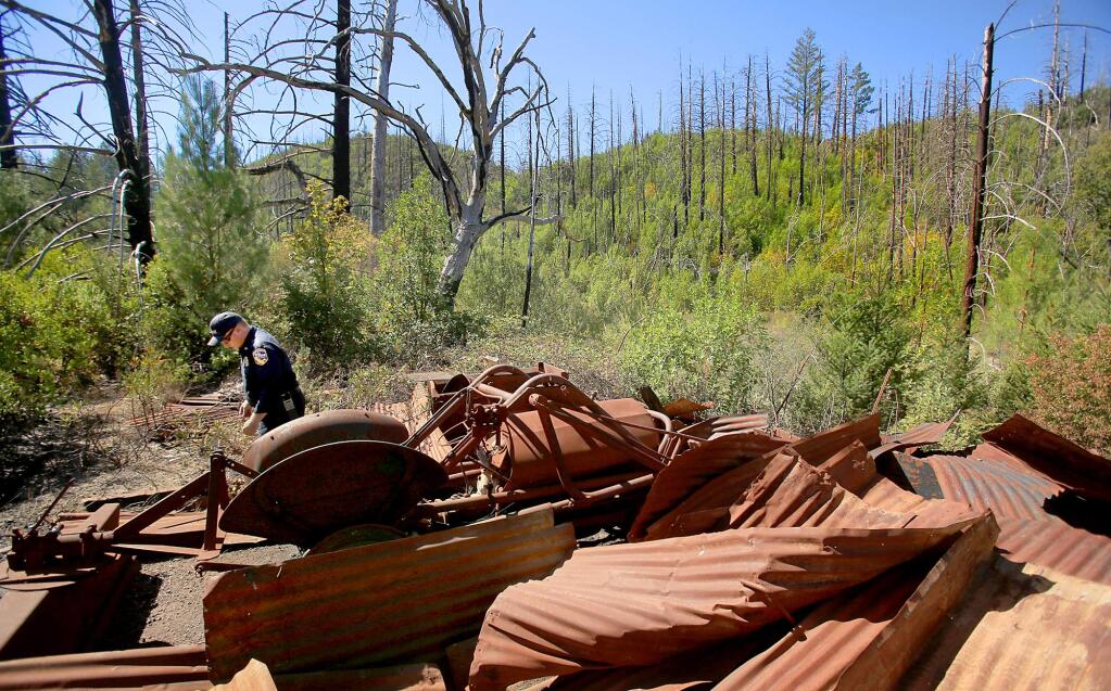 Cal Fire's Marshall Turbeville looks over the remnants of a barn and its contents, destroyed during the Geysers fire which swept through Pine Flat and the Mayacmas Mountains 11 years ago this month, on Wednesday Sept. 9, 2015. (Kent Porter / Press Democrat)