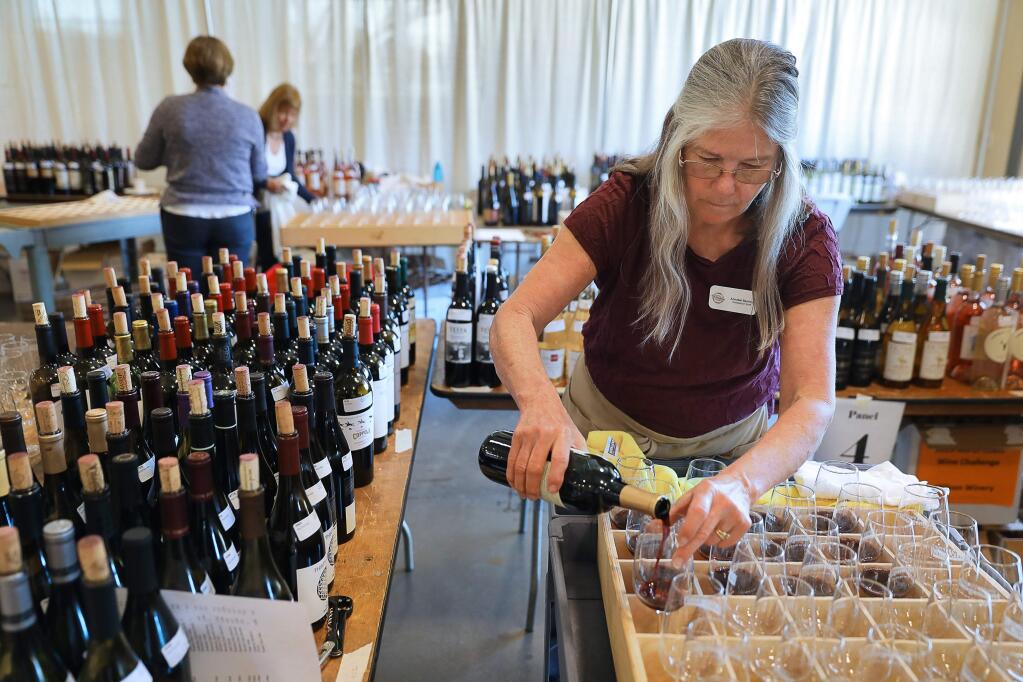 Annabel Bentley prepares glasses of wine for judging during the North Coast Wine Challenge in Santa Rosa on Tuesday, April 9, 2019. (Christopher Chung/ The Press Democrat)