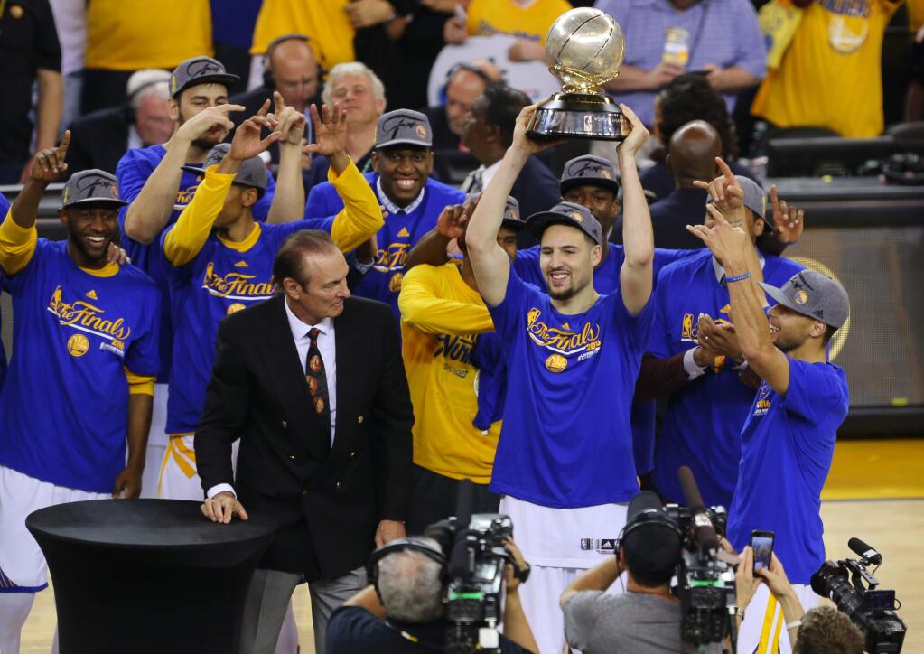 Golden State Warriors' Klay Thompson raises the trophy while celebrating with his teammates after beating the Oklahoma City Thunder in Oakland on Monday, May 30, 2016. The Warriors defeated the Thunder 96-88.(Christopher Chung/ The Press Democrat)