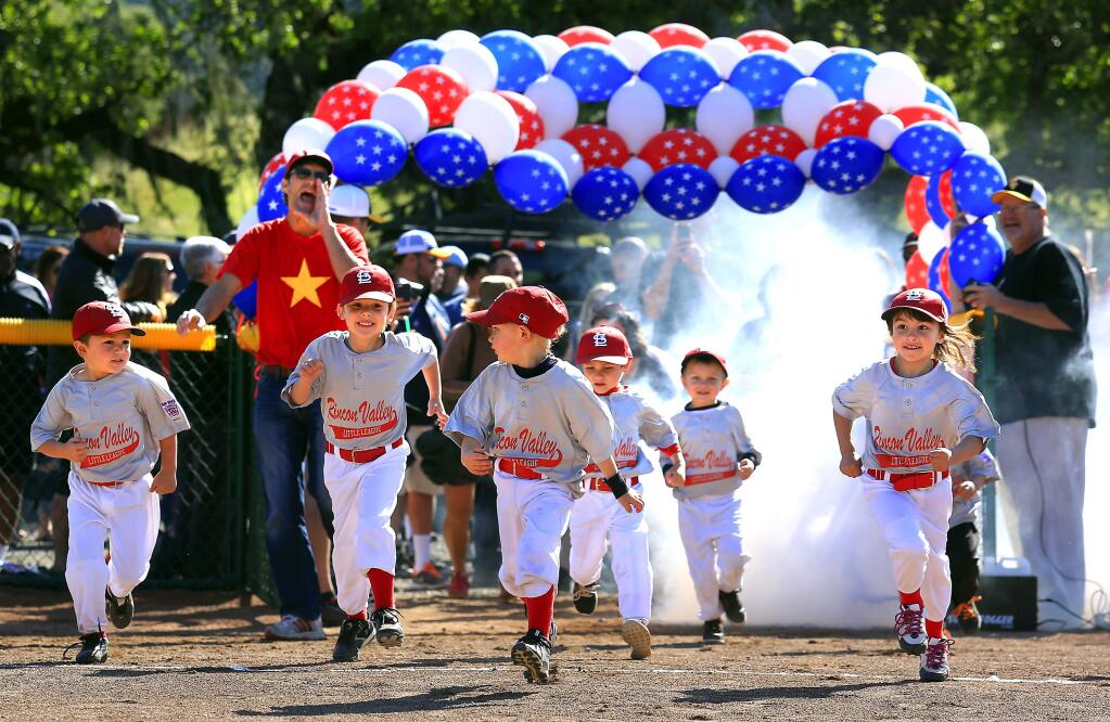 The t-ball Cardinals run onto the field the wrong way as their coach yells for the 5-year-olds to come back during opening day ceremonies at the Rincon Valley Little League on Saturday, April 4, 2015. (Photo by John Burgess)